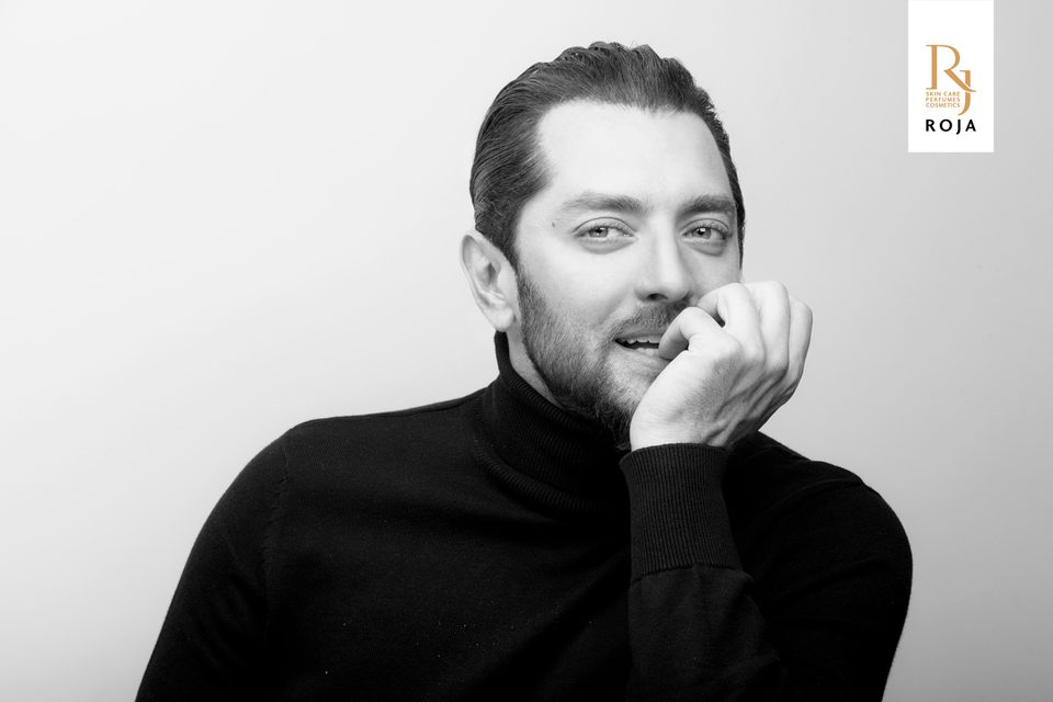 Bahram Radan in a black turtleneck, hand at his chin, campaign portrait for RojaShop