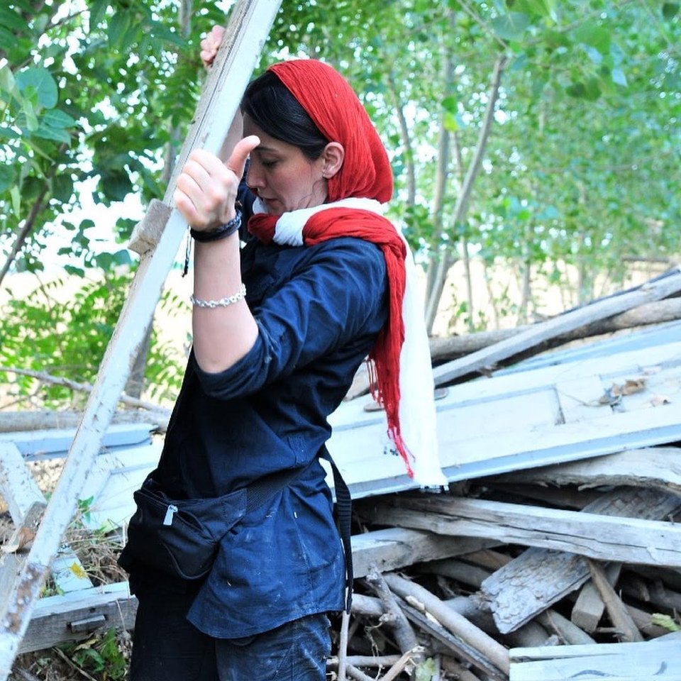 Hedieh Tehrani lifting a long plank from a timber pile