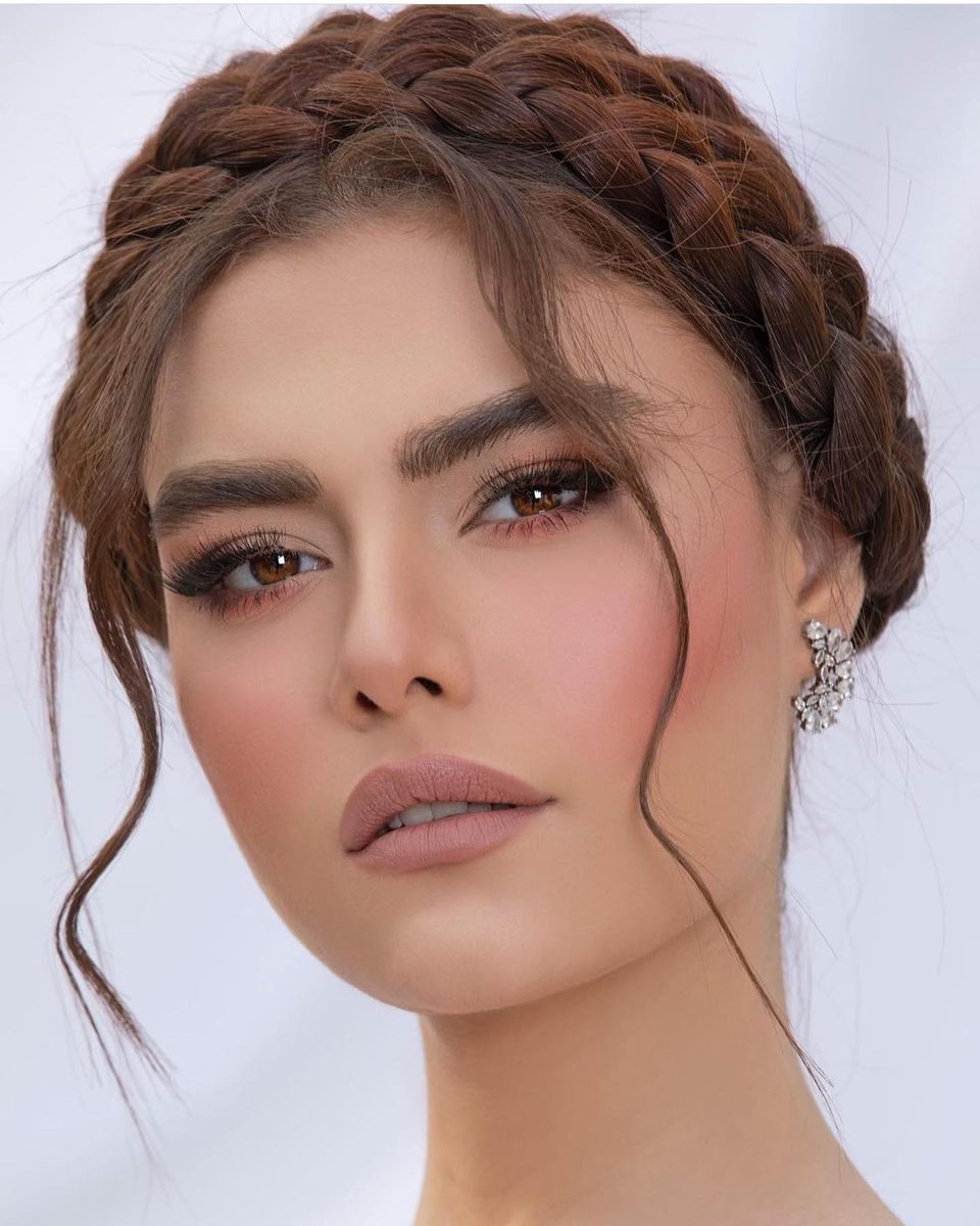 Beauty portrait of a woman with a braided crown and loose curls